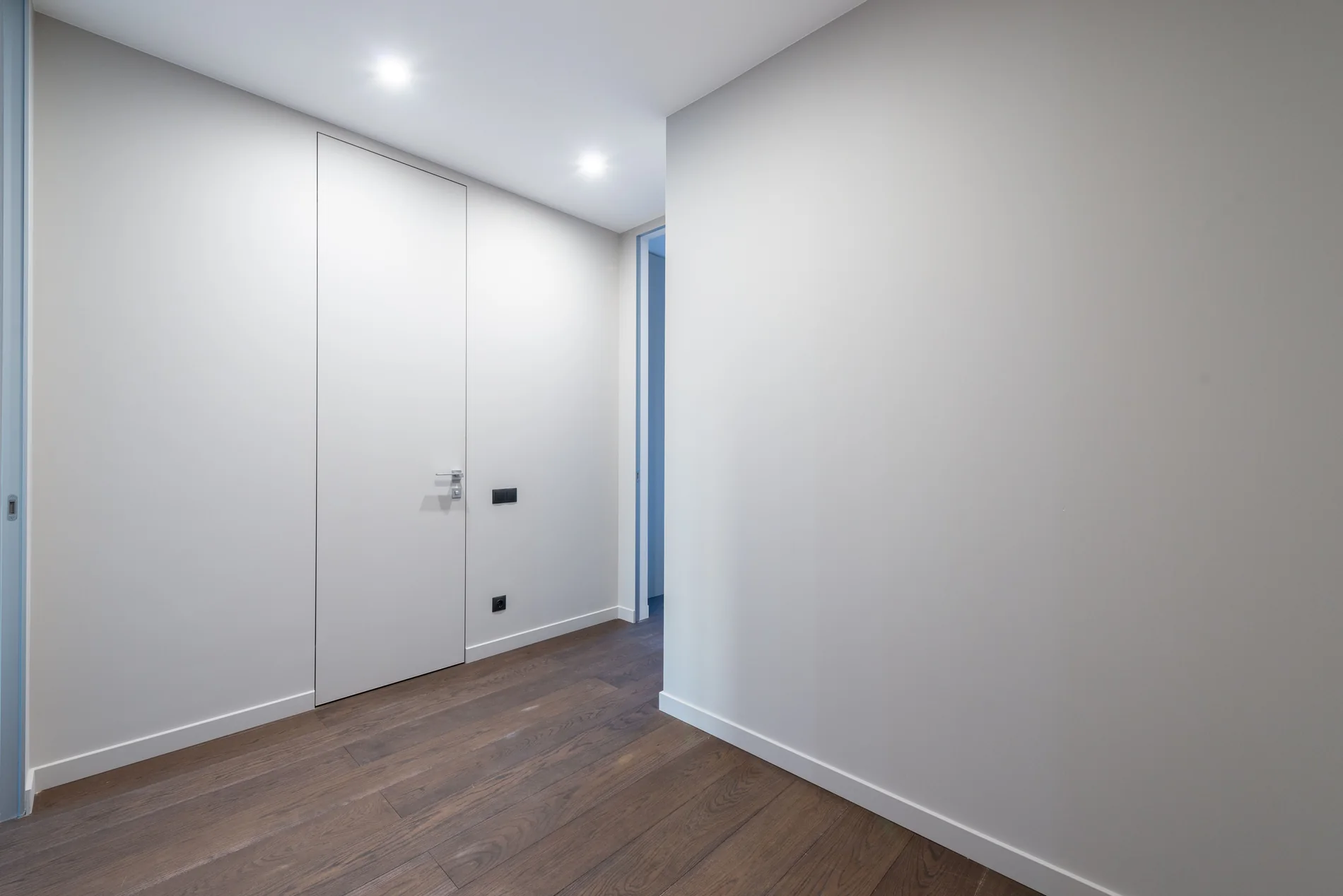 Minimal indoor corridor with doors and timber flooring