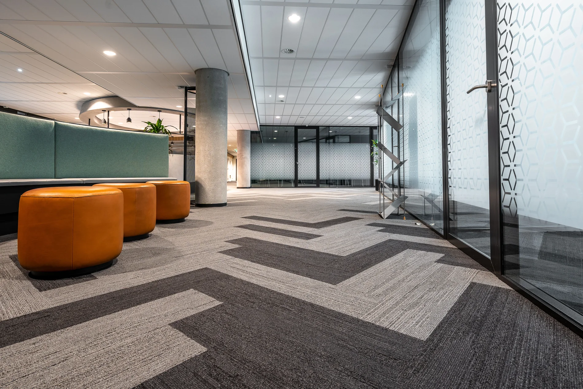 Spacious commercial office interior with glass doors and seating